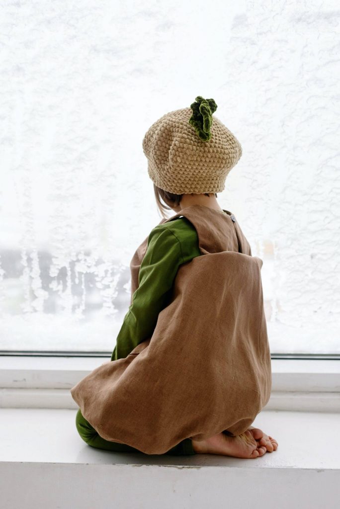 Snow Day Crafts: A child stares out a window at some snow.