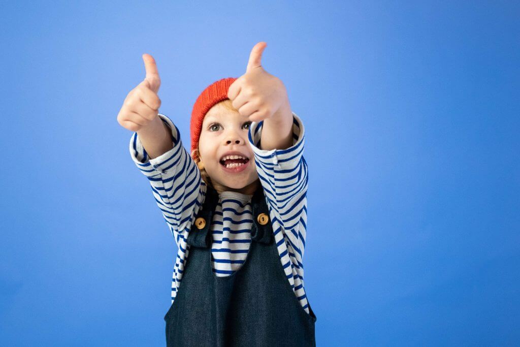 Positive Reinforcement - A happy child gives two thumbs up.
