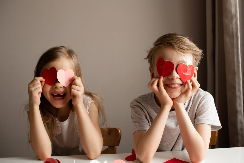 Kids painting red valetine heart card on table at home Valentine's day crafts